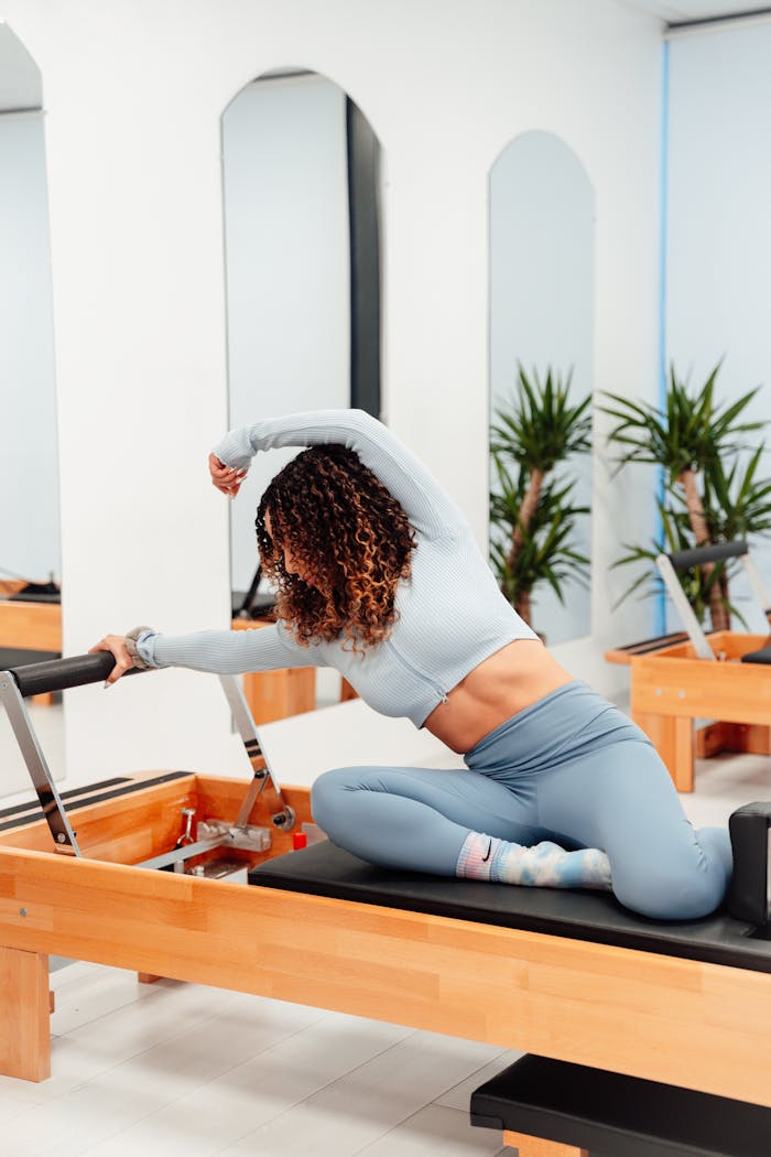 contact-img Woman practicing pilates on reformer machine, promoting healthy lifestyle indoors.